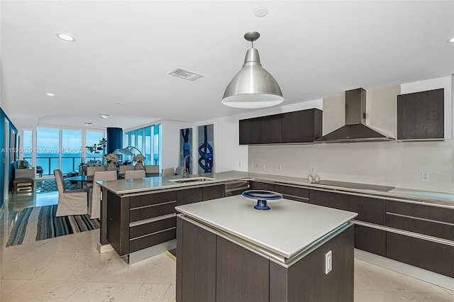 kitchen with sink, a center island, floor to ceiling windows, wall chimney range hood, and black electric stovetop