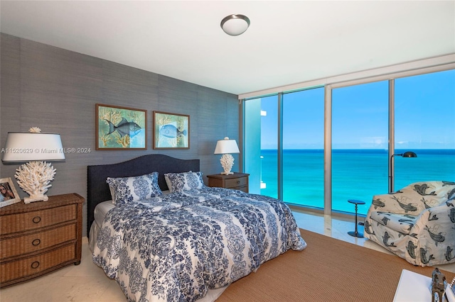 tiled bedroom with access to outside, a wall of windows, and a water view