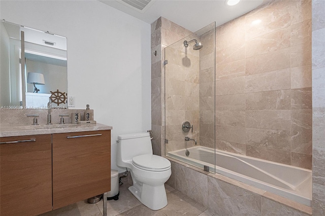 full bathroom with toilet, vanity, bath / shower combo with glass door, and tile flooring