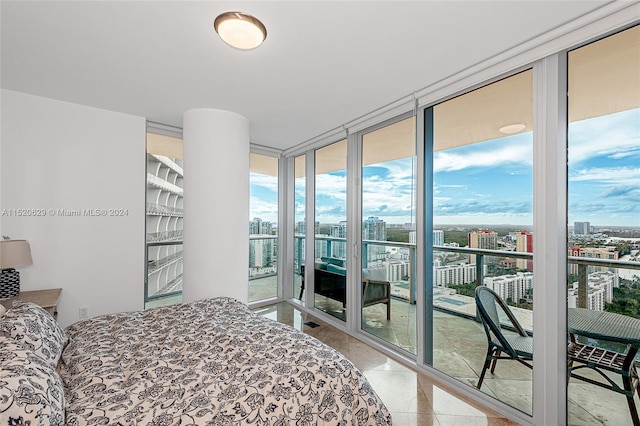 bedroom featuring access to exterior, light tile flooring, and a wall of windows