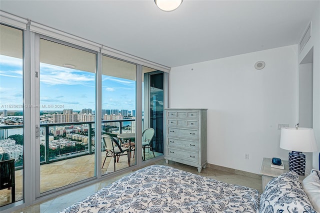 bedroom featuring floor to ceiling windows, light tile flooring, and access to exterior