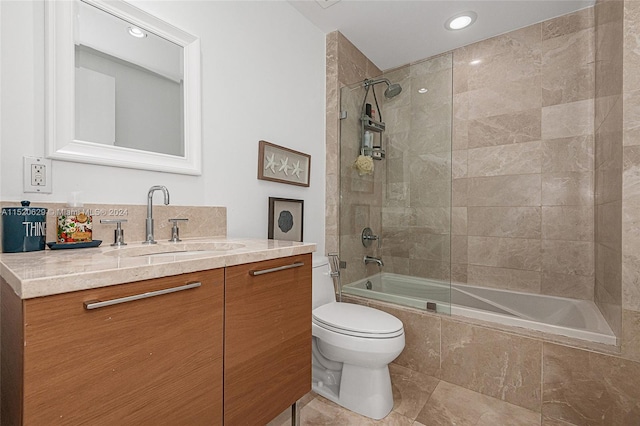 full bathroom featuring tiled shower / bath combo, vanity, tile floors, and toilet