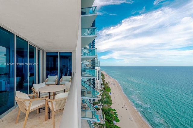 balcony featuring a water view and a view of the beach