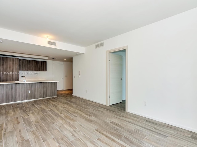 empty room with sink and light hardwood / wood-style flooring