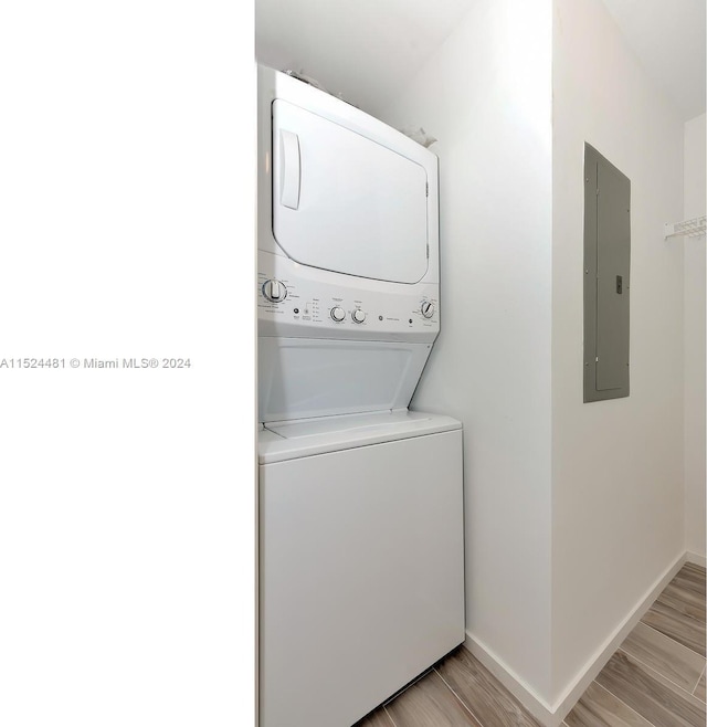 washroom with stacked washer and dryer and light wood-type flooring