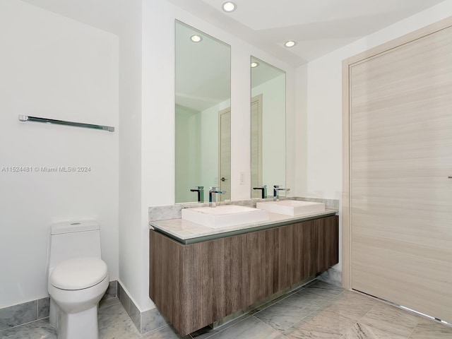 bathroom featuring toilet, vanity with extensive cabinet space, and tile floors