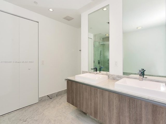 bathroom with double sink vanity, tile floors, and a shower with door