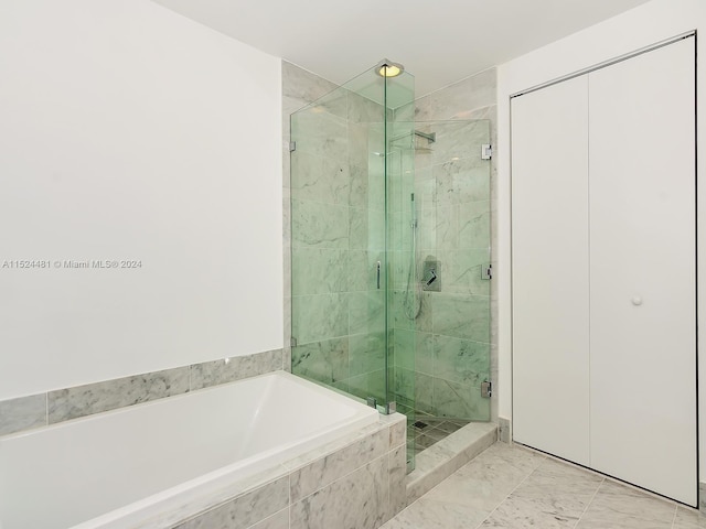 bathroom with shower with separate bathtub and tile floors