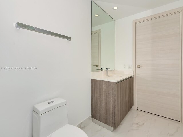 bathroom with oversized vanity, toilet, and tile floors