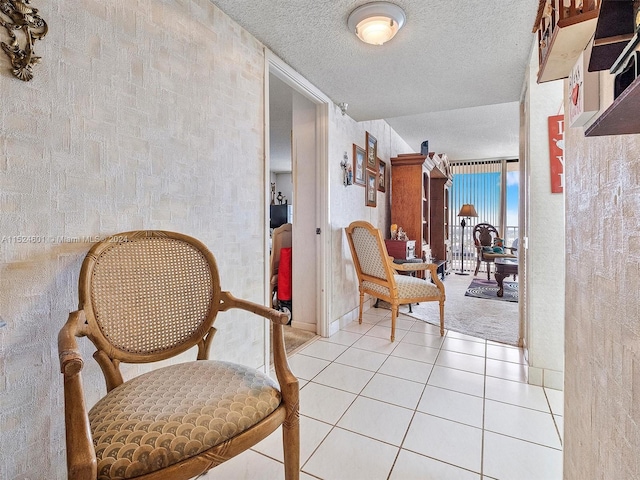 sitting room featuring a textured ceiling and light tile floors