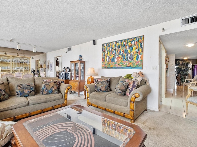 living room with light carpet, rail lighting, and a textured ceiling