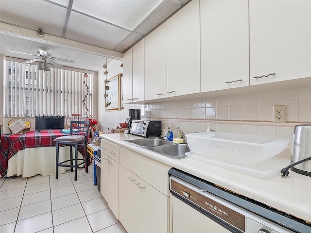 kitchen with white cabinetry, ceiling fan, light tile flooring, sink, and dishwasher