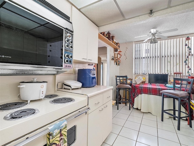 kitchen featuring white cabinets, white stove, and ceiling fan