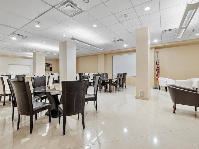 dining space with light tile floors and a drop ceiling