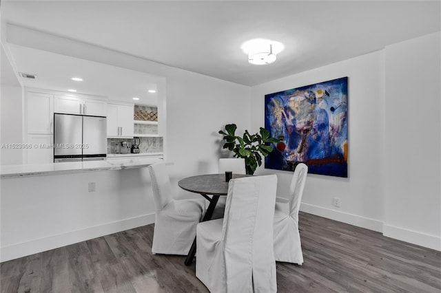 dining area featuring dark wood-style floors, visible vents, recessed lighting, and baseboards