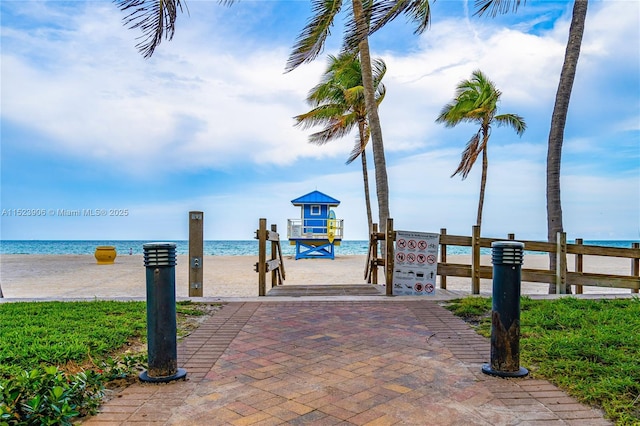 view of dock featuring a water view and a beach view