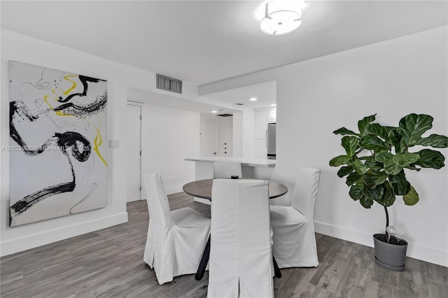 dining room featuring visible vents, baseboards, and wood finished floors