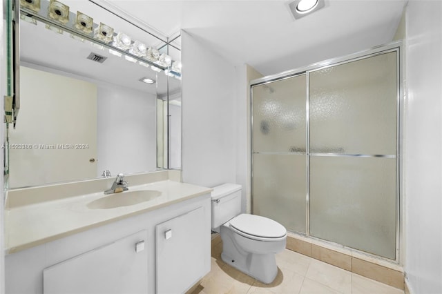 bathroom featuring a shower with shower door, vanity, tile patterned floors, and toilet