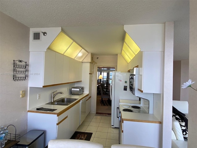 kitchen with white cabinetry, white dishwasher, sink, and light tile flooring