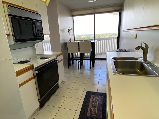 kitchen with white cabinets, white range with electric cooktop, sink, and light tile floors