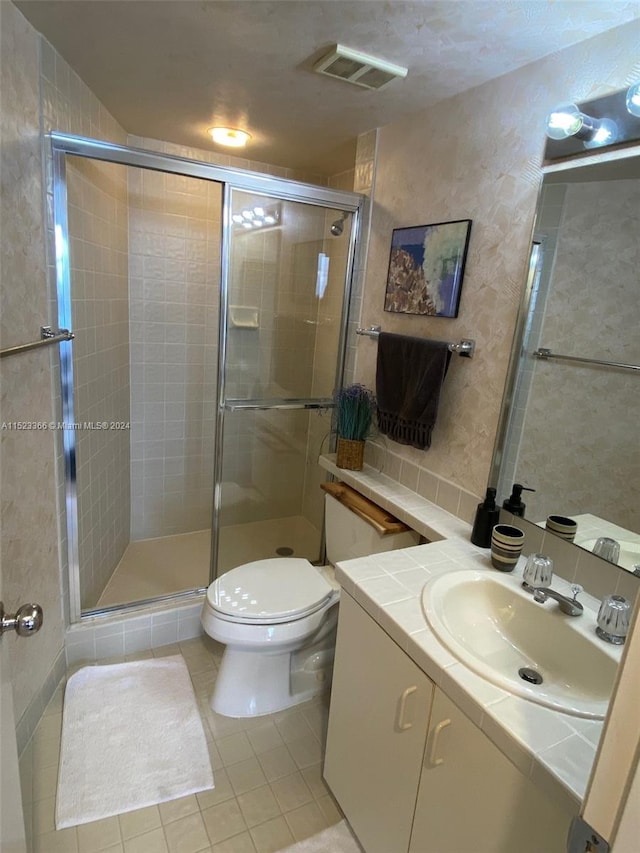 bathroom featuring tile walls, walk in shower, toilet, tile flooring, and large vanity