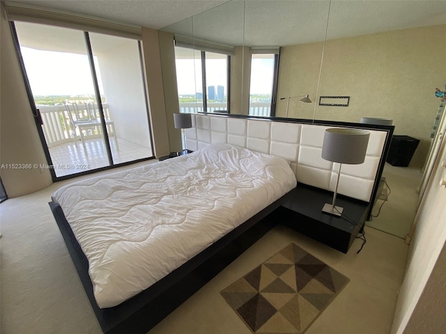 bedroom with carpet, access to outside, and a textured ceiling