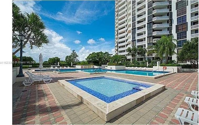 view of swimming pool with a patio area and a community hot tub