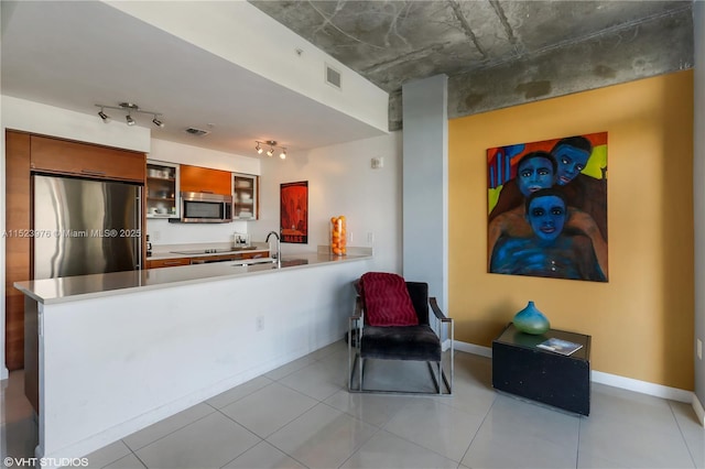 kitchen featuring sink, track lighting, stainless steel appliances, and kitchen peninsula