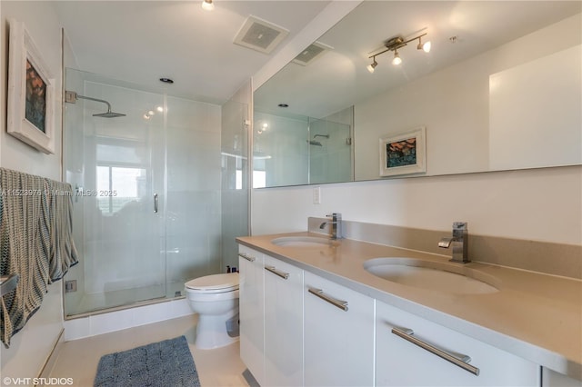 bathroom with vanity, a shower with shower door, tile patterned floors, and toilet