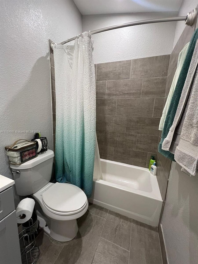 full bathroom with shower / tub combo, toilet, tile floors, and vanity