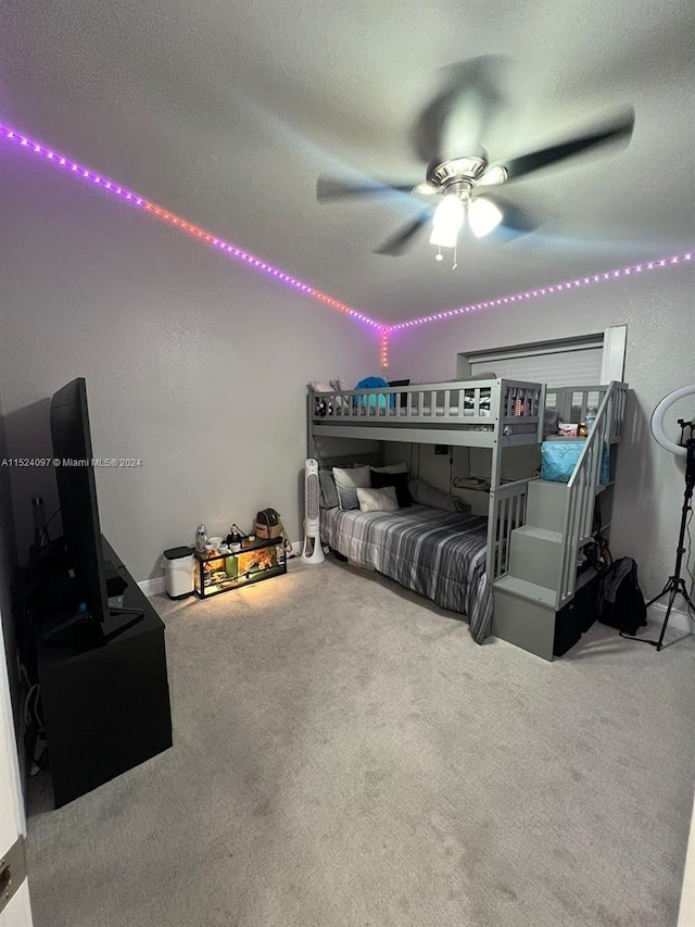 carpeted bedroom featuring ceiling fan and a textured ceiling