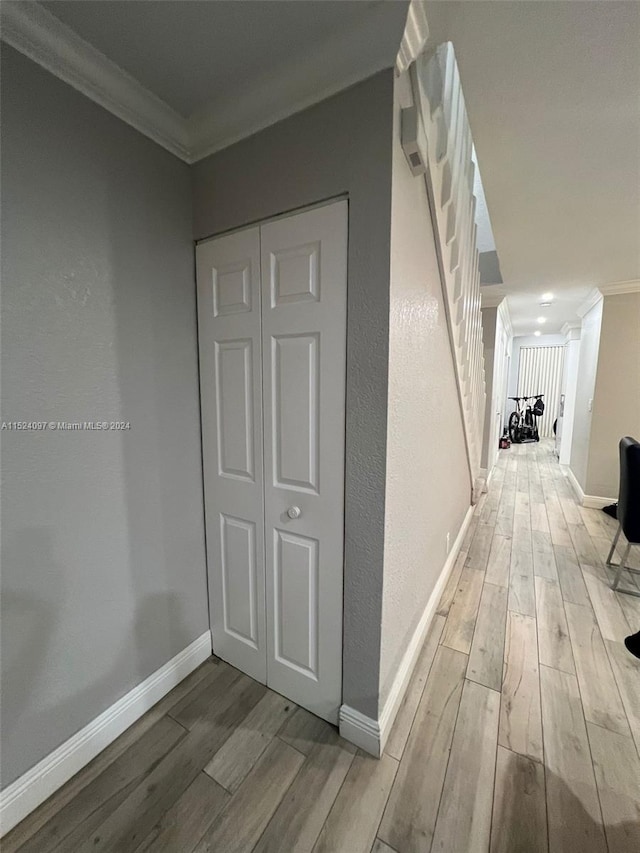 hall with crown molding and light wood-type flooring