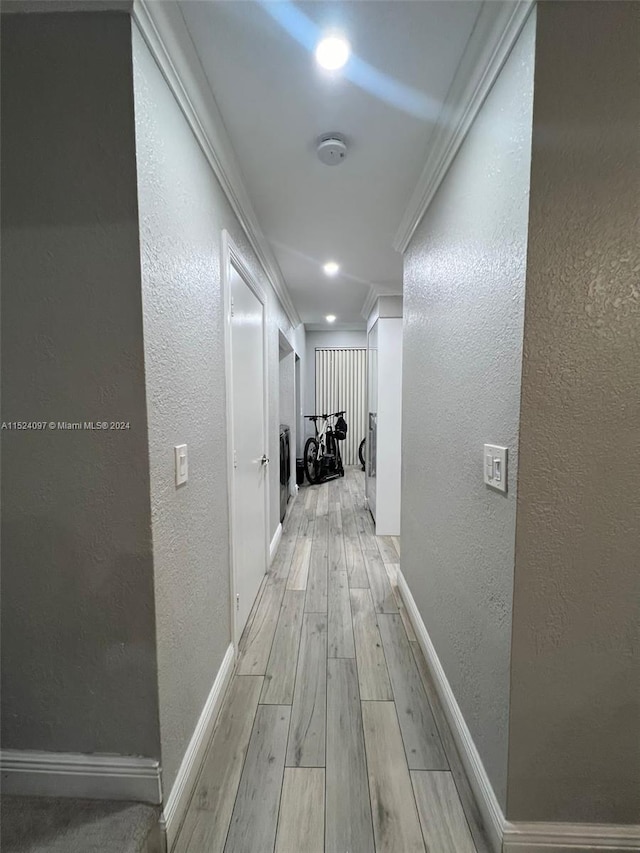 hall with crown molding and light hardwood / wood-style floors