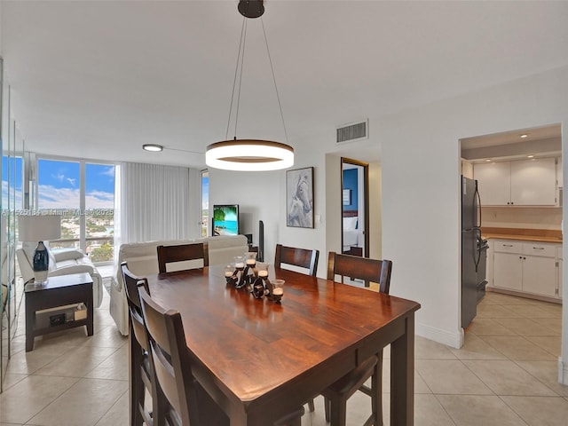 dining area with light tile patterned floors, a wall of windows, visible vents, and recessed lighting