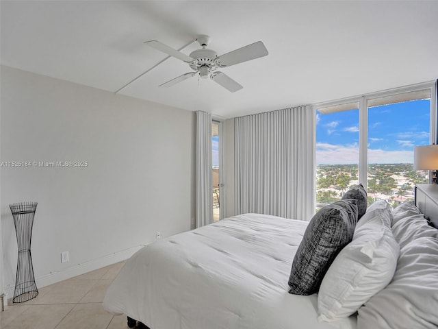 bedroom with ceiling fan, baseboards, and light tile patterned floors