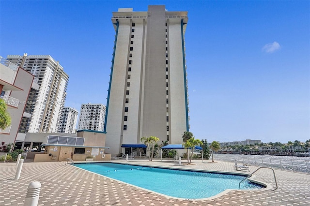 community pool with a view of city and a patio