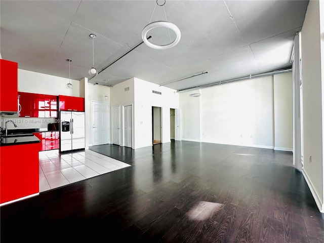 interior space with stainless steel fridge, sink, range with electric cooktop, tasteful backsplash, and hardwood / wood-style flooring