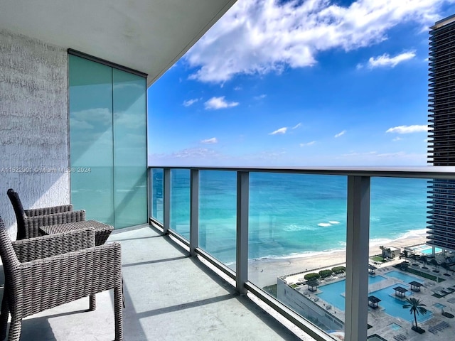 balcony featuring a beach view and a water view