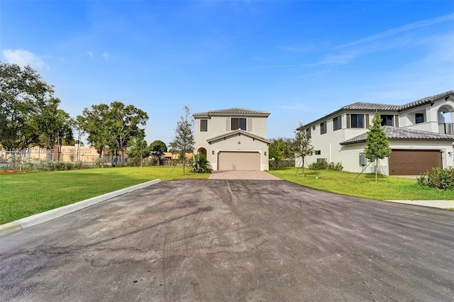 view of front of house with a tile roof, driveway, an attached garage, a front yard, and stucco siding
