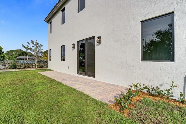 rear view of property with a yard and a patio area