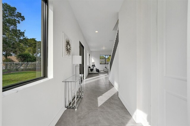 hall with plenty of natural light and light tile flooring