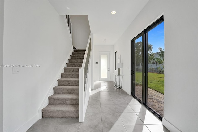 entryway with stairway, light tile patterned floors, baseboards, and recessed lighting