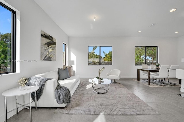 tiled living area featuring baseboards, visible vents, and recessed lighting