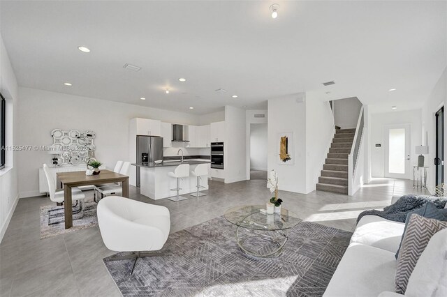 living room featuring light tile floors and sink