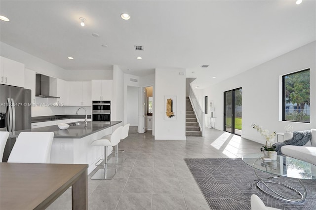 living area with light tile patterned flooring, baseboards, visible vents, recessed lighting, and stairway