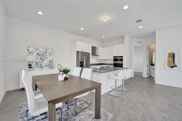 dining space featuring radiator heating unit and light tile floors