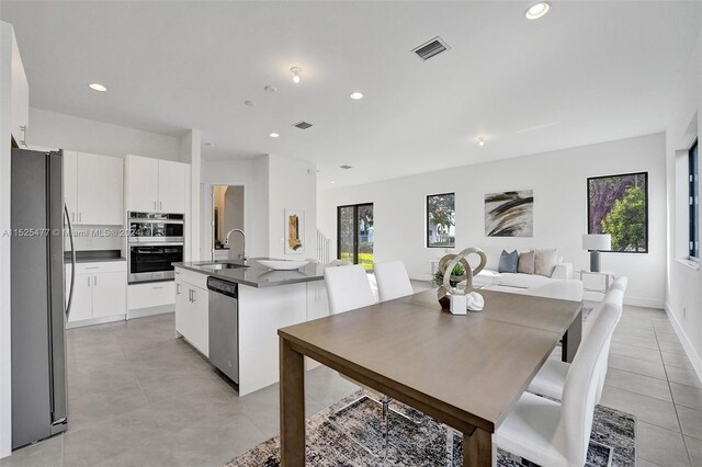 dining area with light tile floors and sink