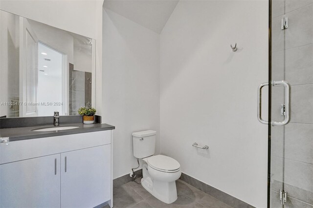 bathroom with toilet, tile floors, an enclosed shower, and oversized vanity