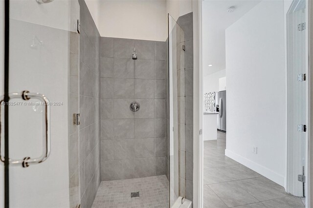 bathroom featuring tile flooring and a shower with shower door