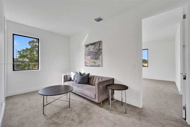 carpeted living room with baseboards and visible vents